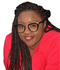 Person with braided hair and glasses wearing a red shirt, looking towards the camera.